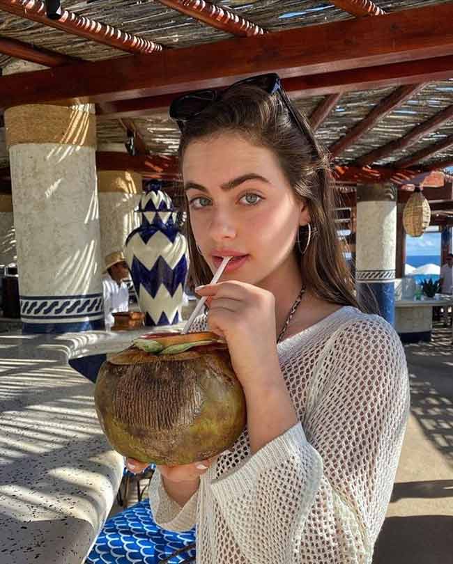 ảnh gái xinh uống nước dừa bên bãi biển